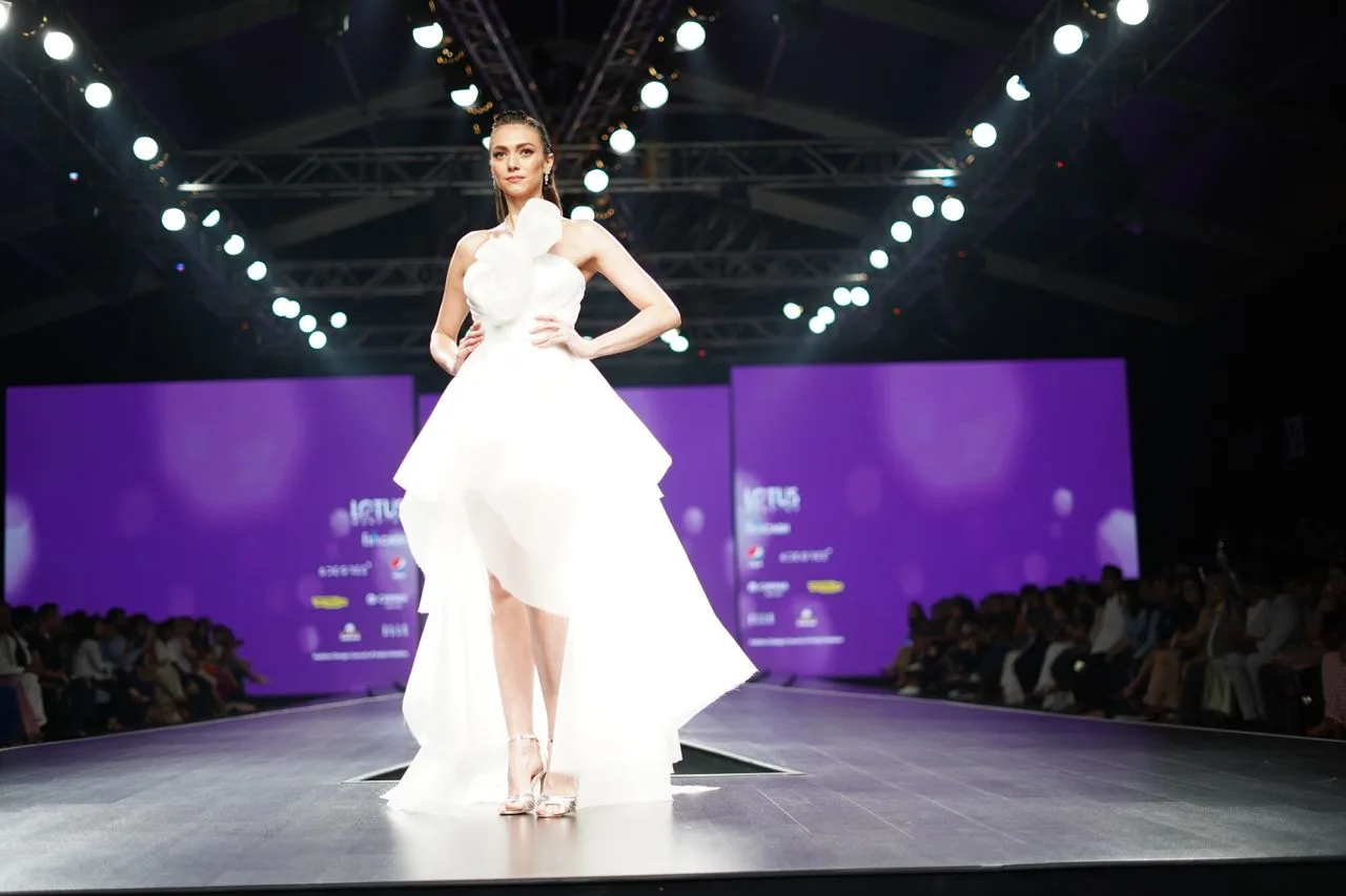 Modelo usando vestido branco em uma passarela de desfile de moda